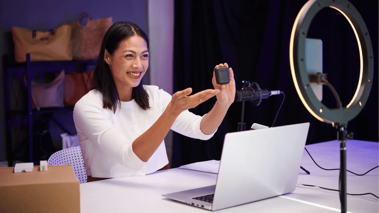Woman demonstrating a small electronic product on camera with ring light for team collaboration