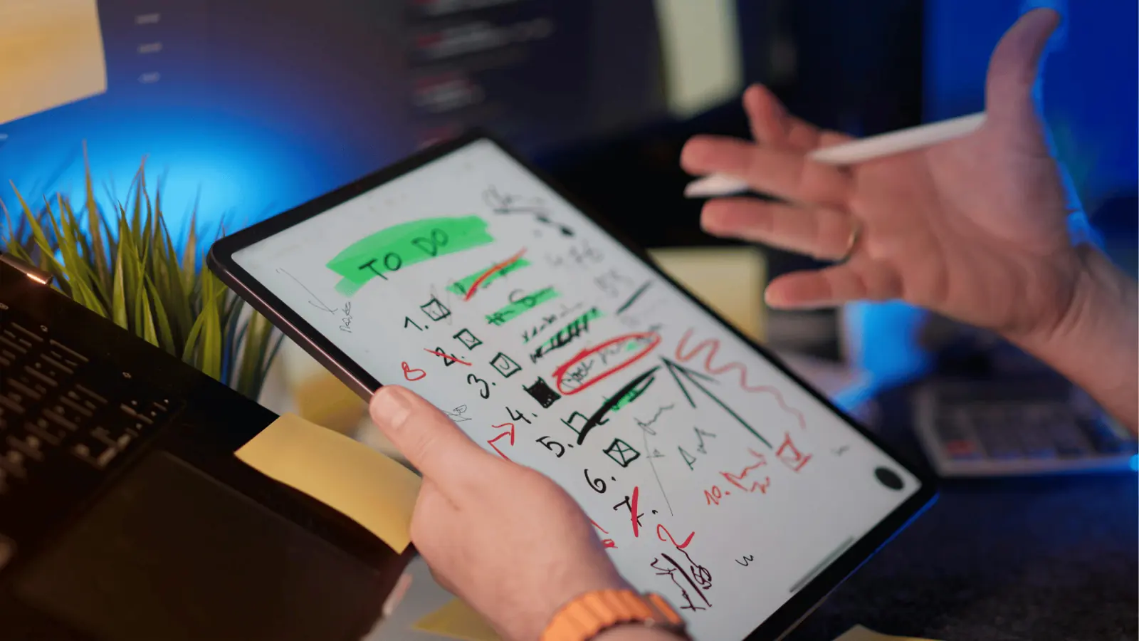 Person holding tablet showing handwritten checklist with stylus and crossed-out items