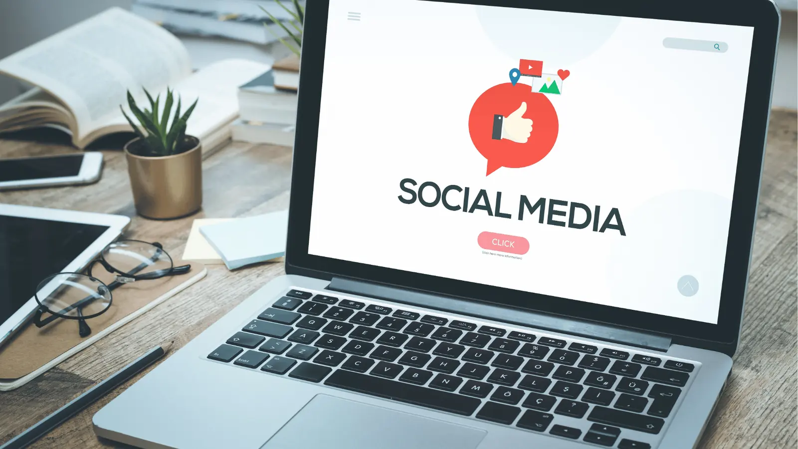Laptop on wooden desk showing social media graphic with workspace items for inbox management