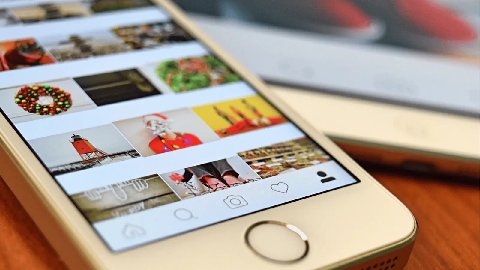 Close-up of smartphone showing a social media photo grid and navigation icons for multi-brand management