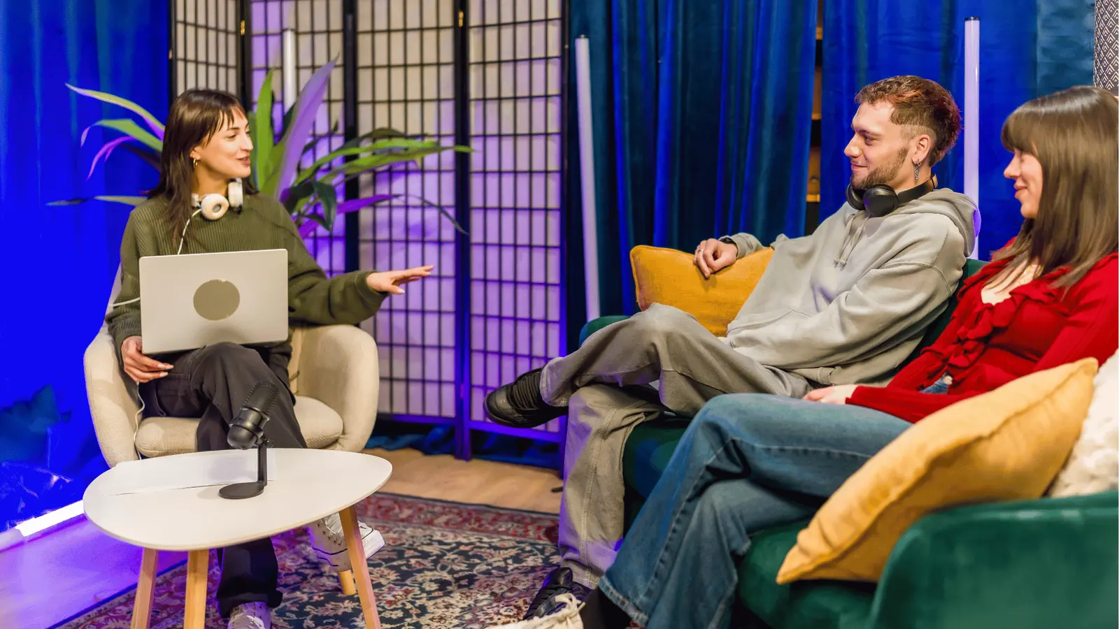 Three people in a cozy studio recording a casual podcast interview for content review