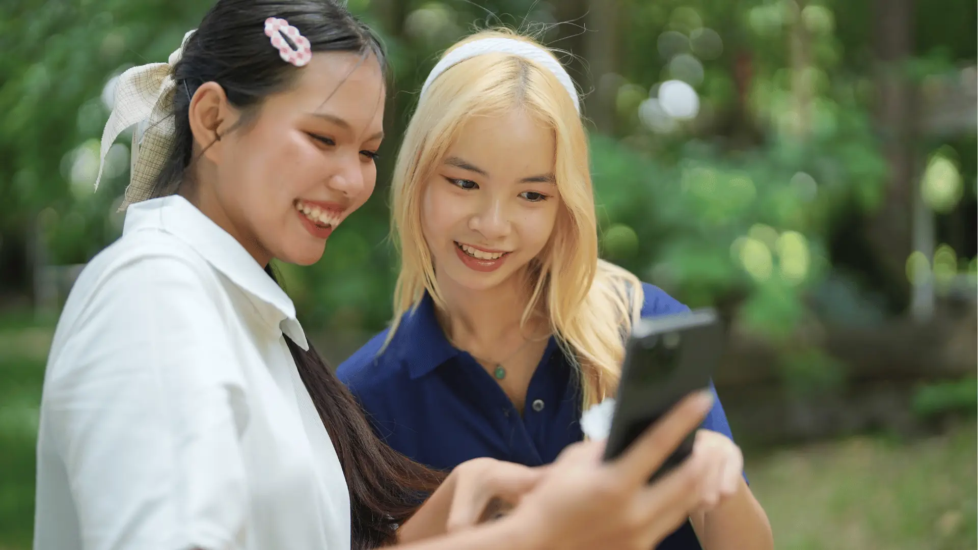 Vrienden lachen buiten om iets op een telefoon