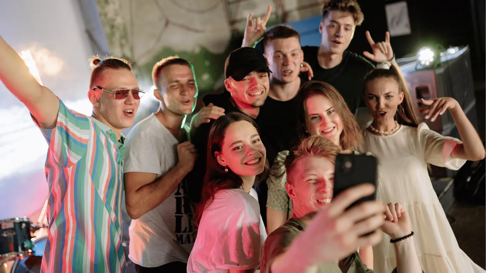 Group of young adults smiling and posing for a selfie at a party for creative production