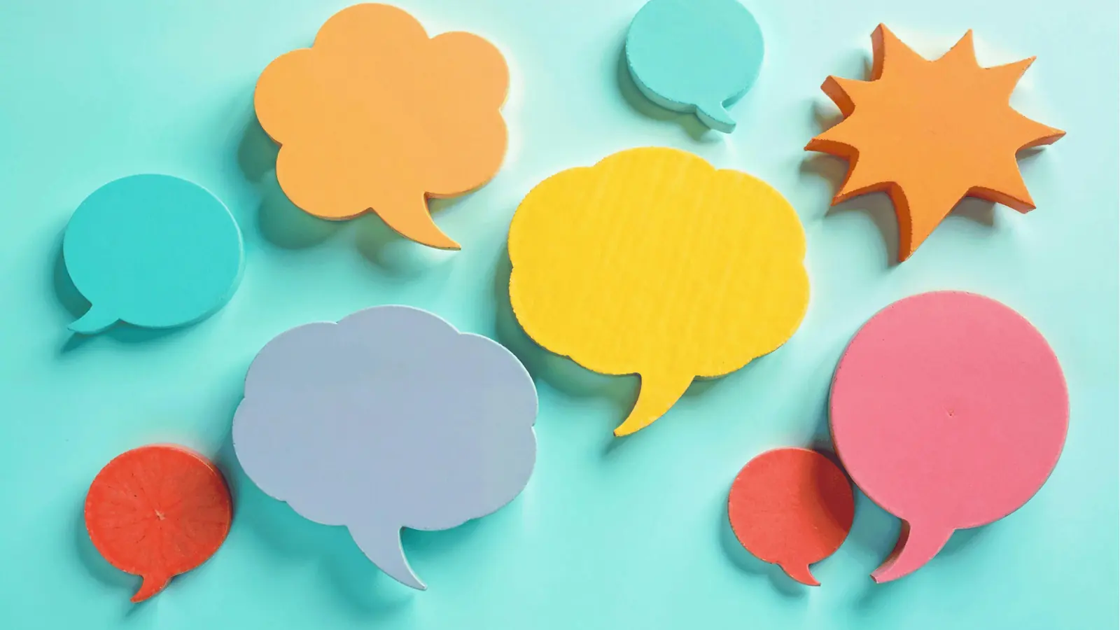 Colorful speech bubble cutouts arranged on a light teal background for workflow