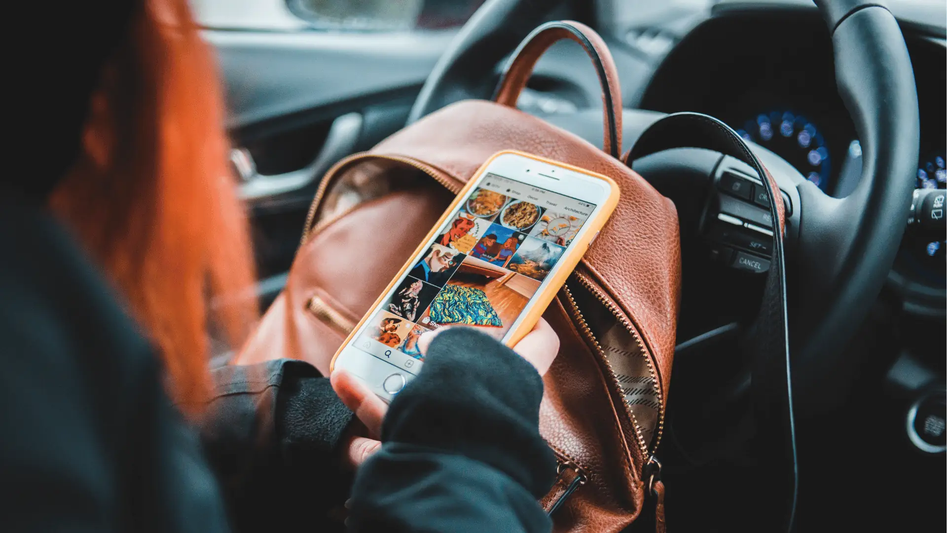 Hand holding smartphone showing photo grid on backpack inside car for AI-assisted workflow