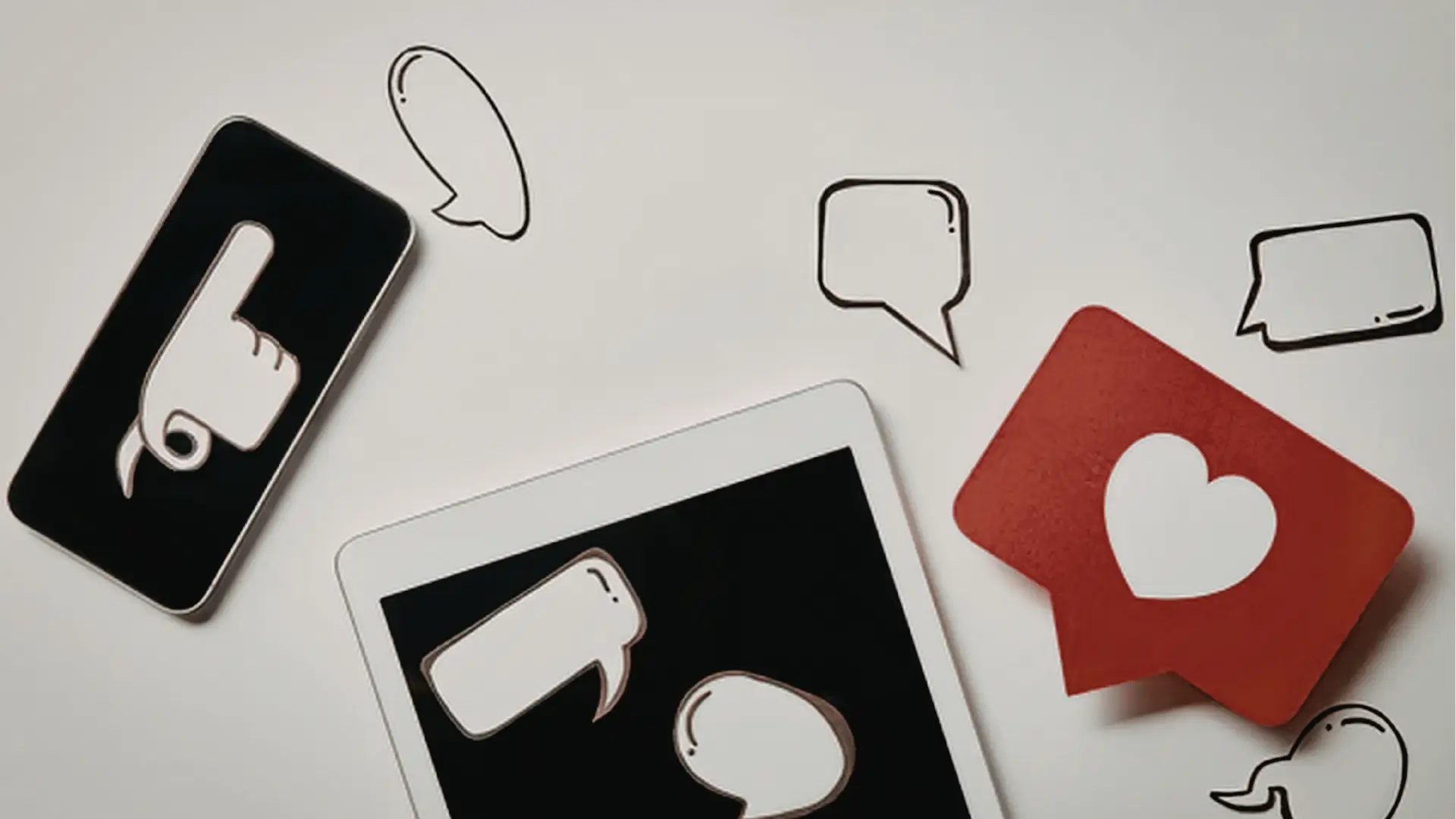 Flat lay of devices and speech bubble icons with a red heart like symbol for AI-assisted workflow