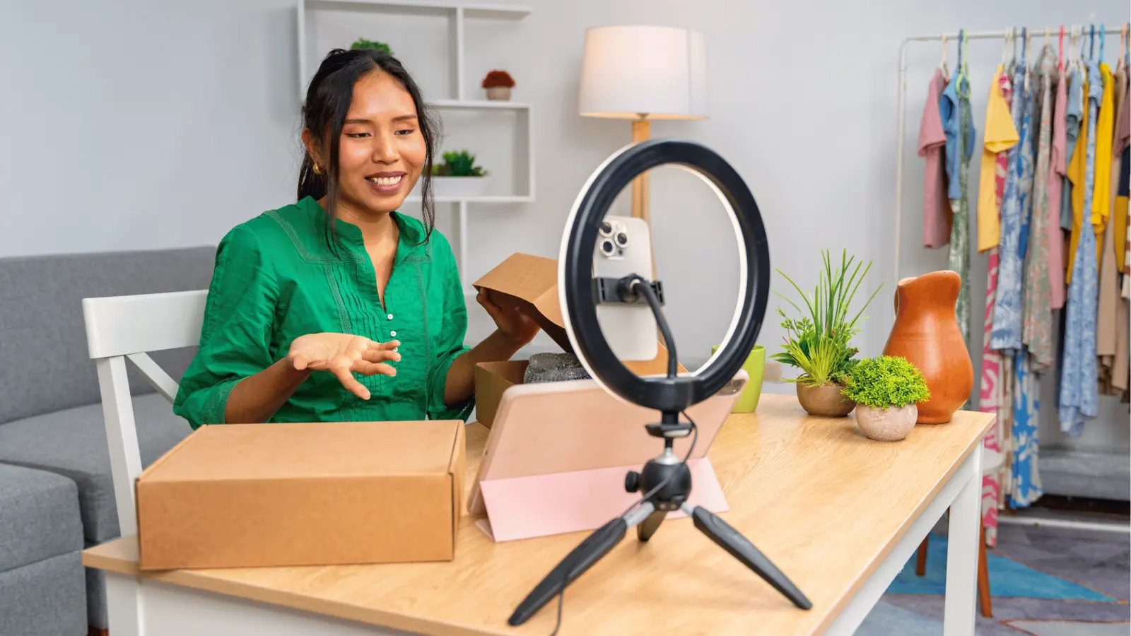 Woman unboxing a product on video with ring light and smartphone for content calendar