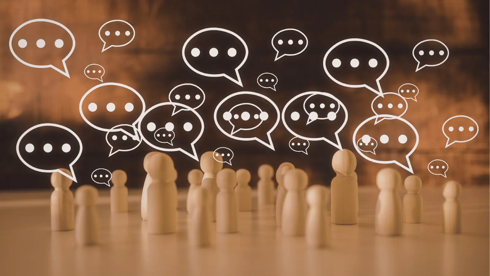 Wooden peg people with many drawn speech bubbles over blurred background for content review
